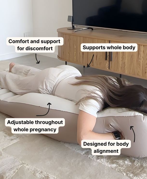 Pregnant woman lying face down using a belly sleep pregnancy pillow for comfort
