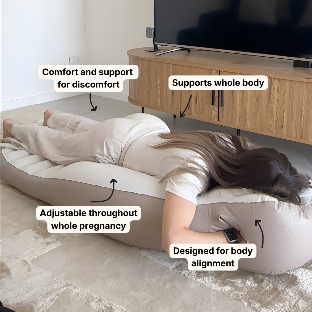 Pregnant woman lying face down using a belly sleep pregnancy pillow for comfort